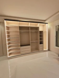 Custom Minimalist Light Oak Walk-in Closet with Central Island and LED Strip Lighting for Dressing Room